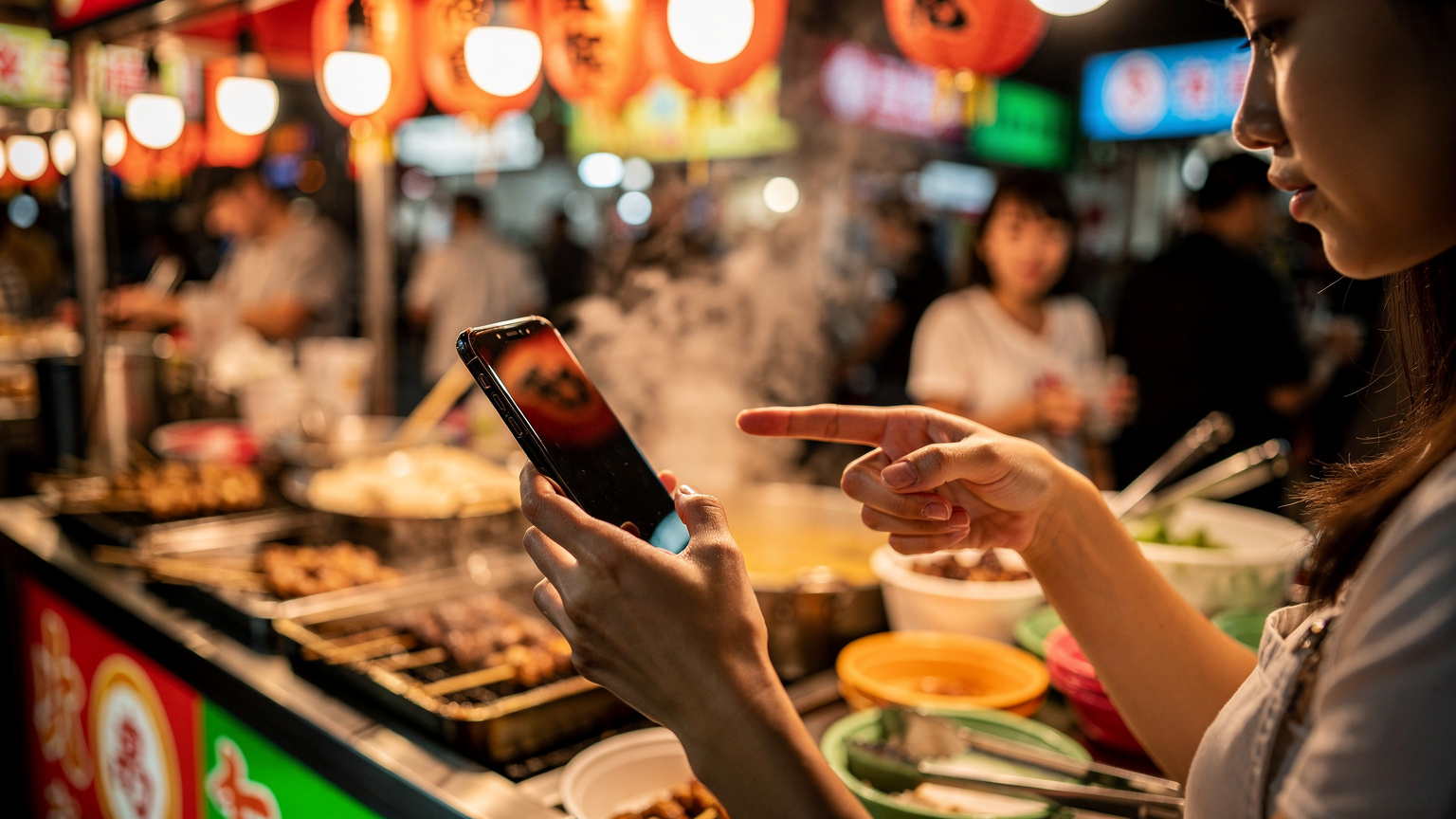 台北のナイトマーケットで、地元の屋台料理を選びながらスマートフォンで友人と連絡を取っている旅行者の手元。周囲は活気にあふれている。