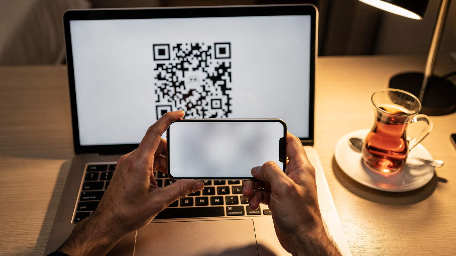 O persoană scanează un cod QR de pe un laptop cu smartphone-ul său, activând un eSIM într-un hotel din Istanbul.