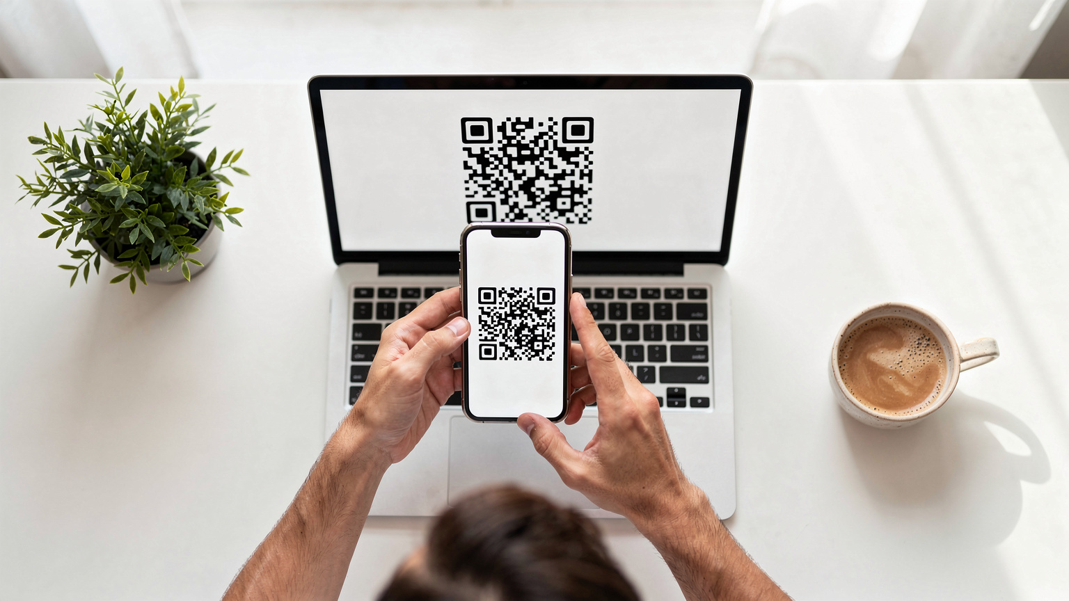 Des mains saisissent un smartphone pour scanner un QR code affiché sur un écran d'ordinateur portable, illustrant le processus d'installation d'une eSIM à domicile.