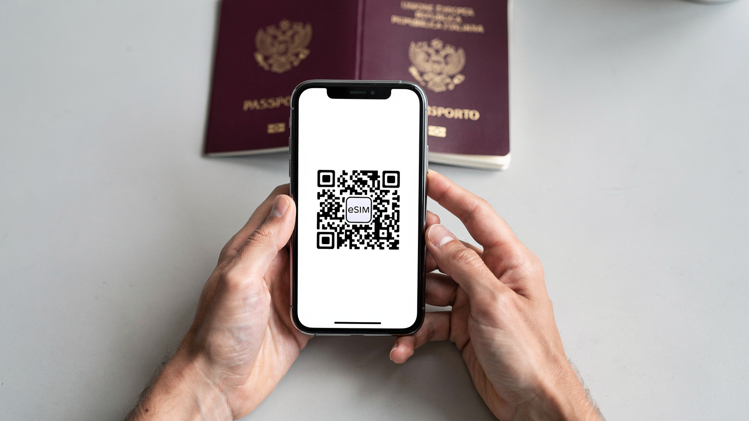 Delle mani tengono uno smartphone mostrando il processo di scansione di un codice QR per l'attivazione di una eSIM, con un passaporto italiano aperto in sottofondo, suggerendo la facilità e la sicurezza della configurazione in viaggio.