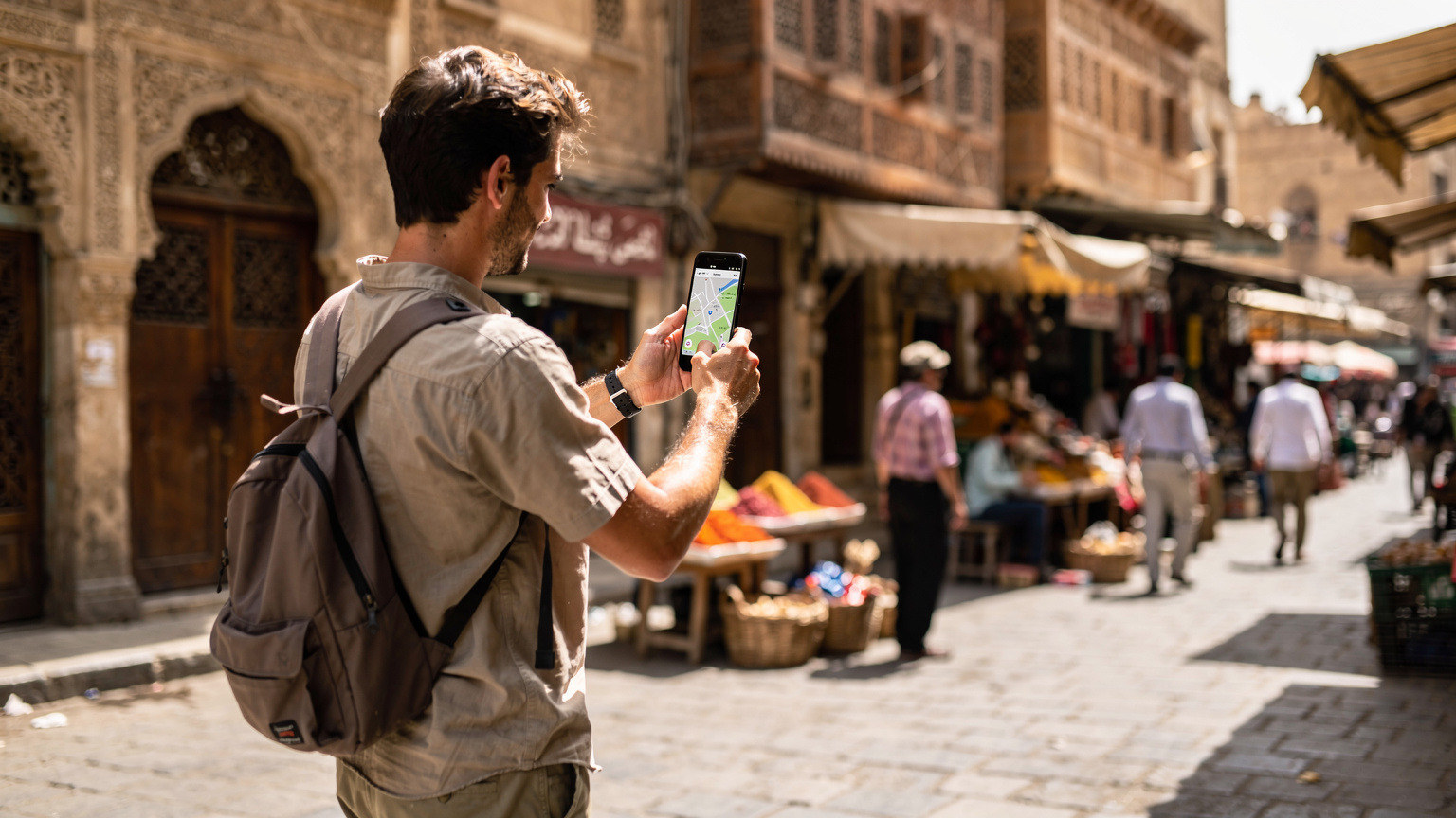 Ein Reisender zeigt sein Smartphone mit einer geöffneten Karte in einer belebten Fußgängerzone in Kairo, wobei historische Gebäude im Hintergrund verschwimmen.
