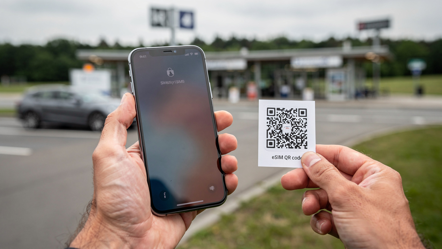 Nahaufnahme eines Smartphones, das einen QR-Code für die eSIM-Installation scannt, mit verschwommener Reiselandschaft im Hintergrund.