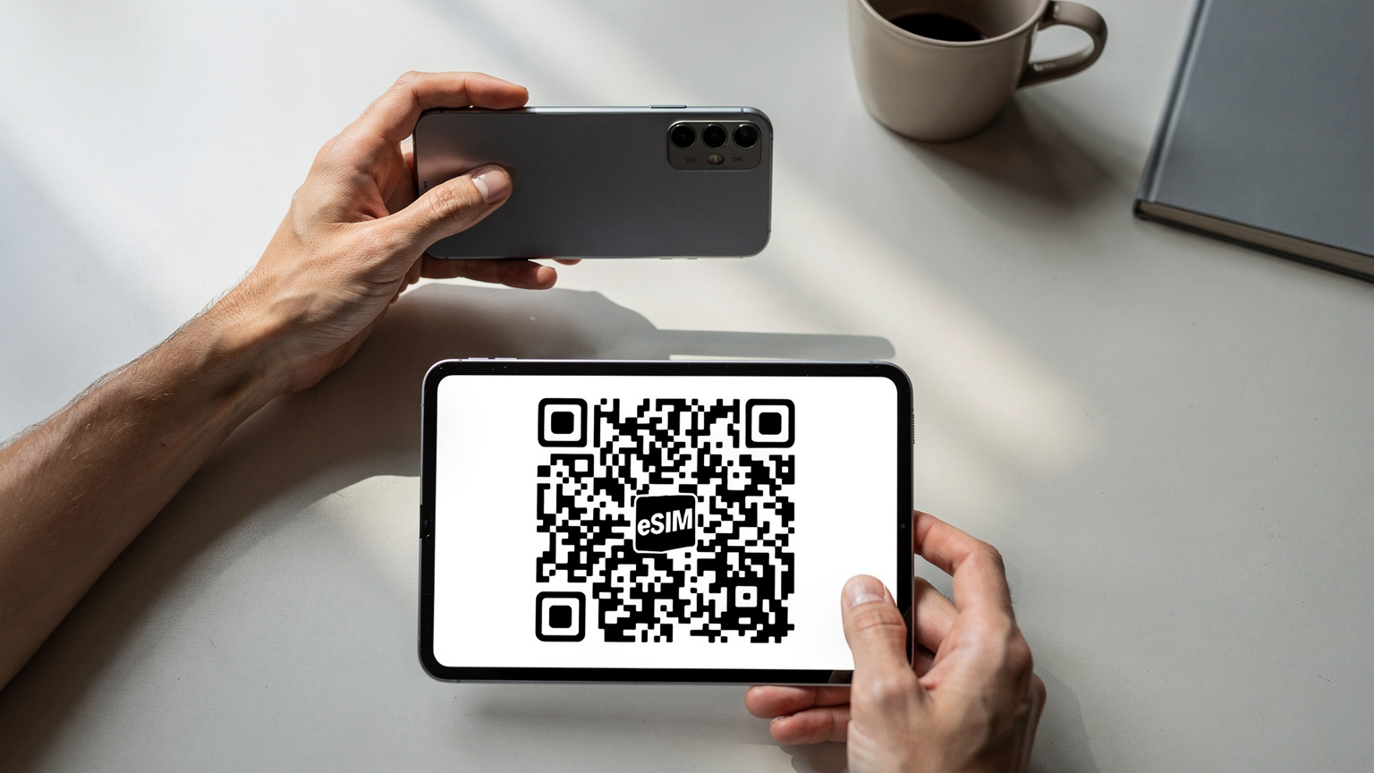 Nahaufnahme von Händen, die ein Smartphone halten, während ein QR-Code für die eSIM-Aktivierung gescannt wird.