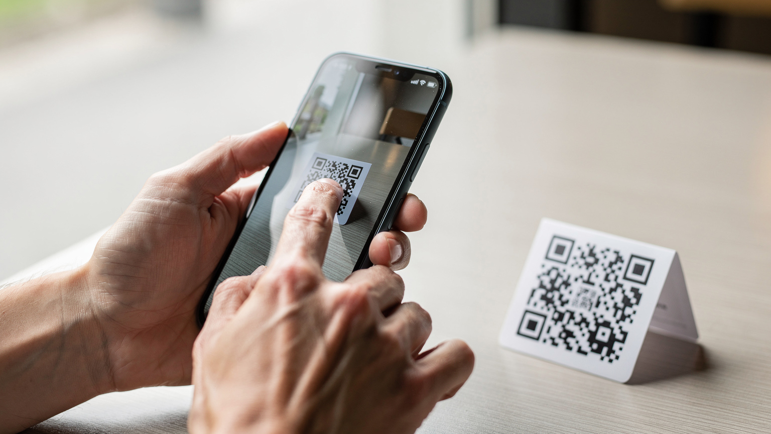 Крупний план рук, що сканують QR-код для активації eSIM.