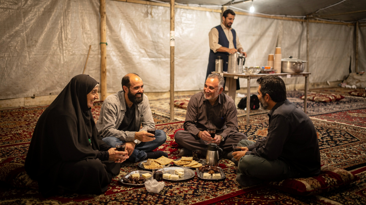 گروهی از زائران ایرانی در حال استراحت در یک موکب ساده در مسیر پیادهروی اربعین، با پسزمینهای از فضای صمیمی و مهماننواز موکبها.