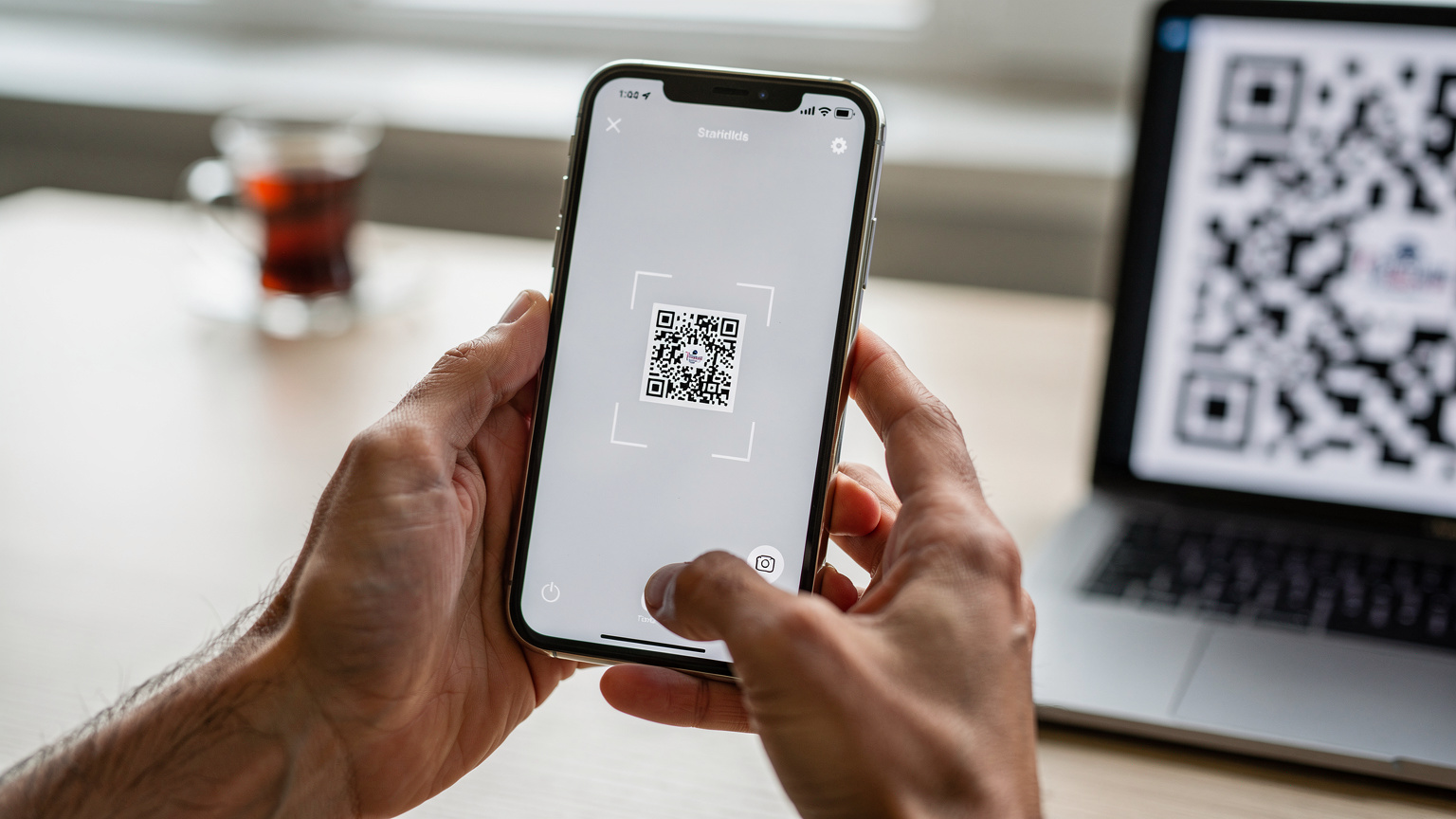 Bir iPhone ekranında eSIM QR kodu tarama arayüzü açıkken, kullanıcının e-postadaki QR kodunu taradığı an.