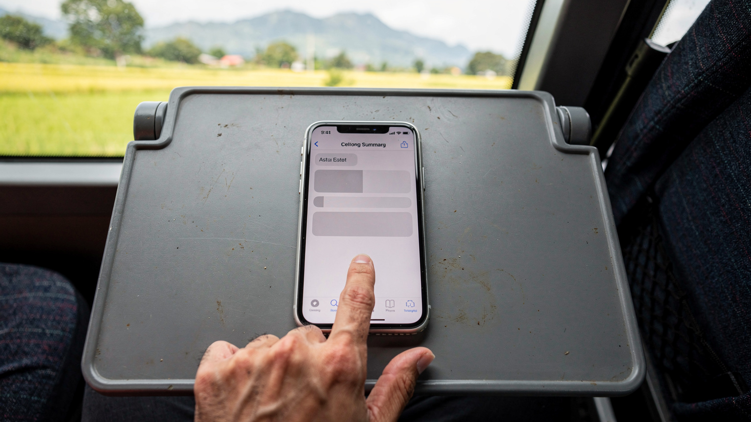 Uma tela de iPhone 18 mostrando as configurações de uso de dados, com várias apps listadas e o indicador de uso de dados em destaque, enquanto o usuário está em um ônibus de longa distância na Ásia.