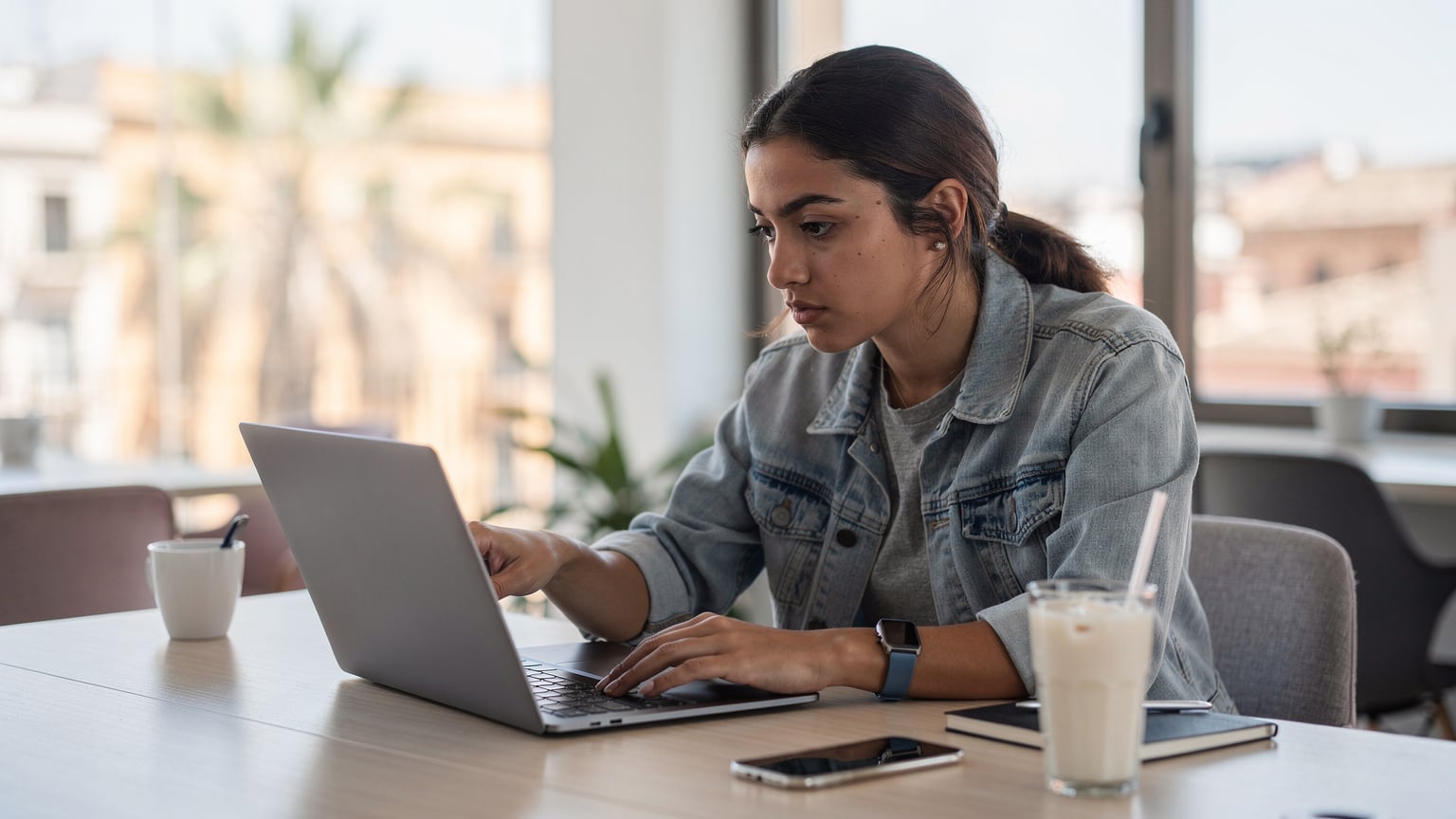 Una viajera revisa las especificaciones de un iPad en la página web de Apple, confirmando que el modelo es 'Wi-Fi + Cellular' para asegurar la compatibilidad con eSIM antes de realizar una compra online.