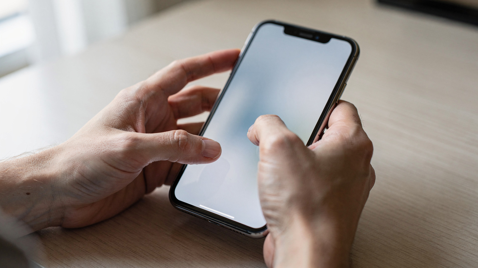 Крупный план рук, настраивающих параметры сотовой связи на iPhone