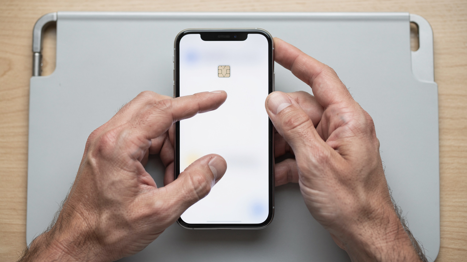 Mãos de um viajante ativando um eSIM em seu smartphone, segurando o telefone com ambas as mãos, focado na tela.