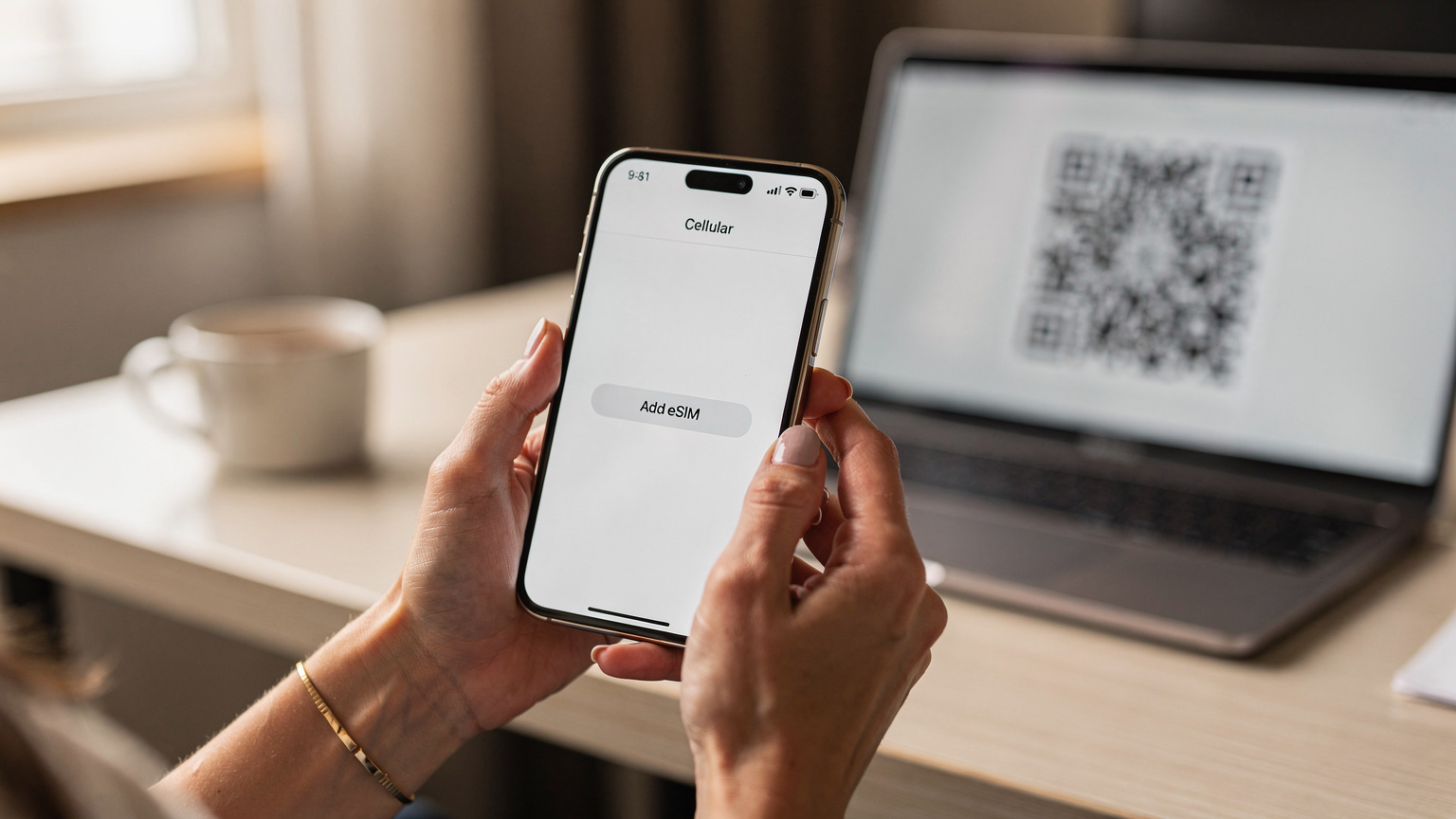 Un gros plan sur les mains d'une mère tenant un smartphone affichant les réglages d'activation d'une eSIM. Un QR code est visible sur un autre écran en arrière-plan, suggérant le processus de scan. La lumière est douce et naturelle, venant d'une fenêtre.