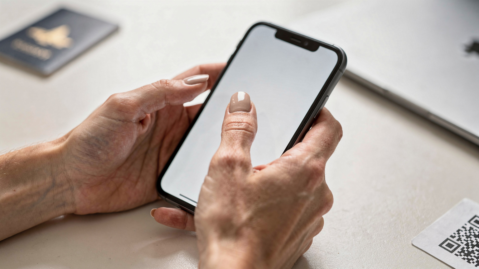 指がスマートフォンの画面に触れ、eSIM設定のQRコードをスキャンしようとしている様子。