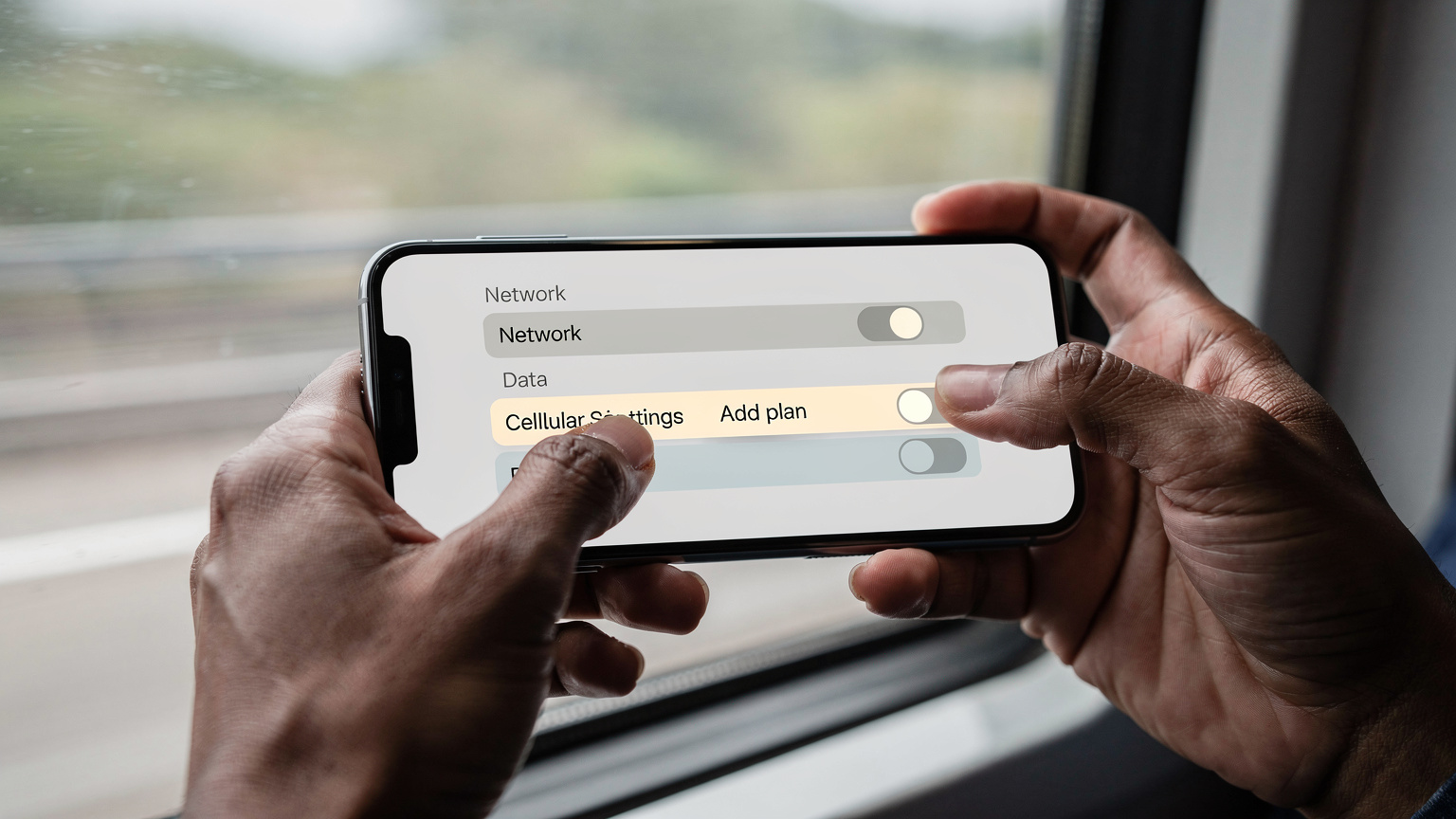 Des mains tenant un smartphone affichant un écran de réglages de données cellulaires, avec l'option d'ajouter un forfait eSIM clairement visible. Le fond est flou, mais on distingue un environnement de voyage.