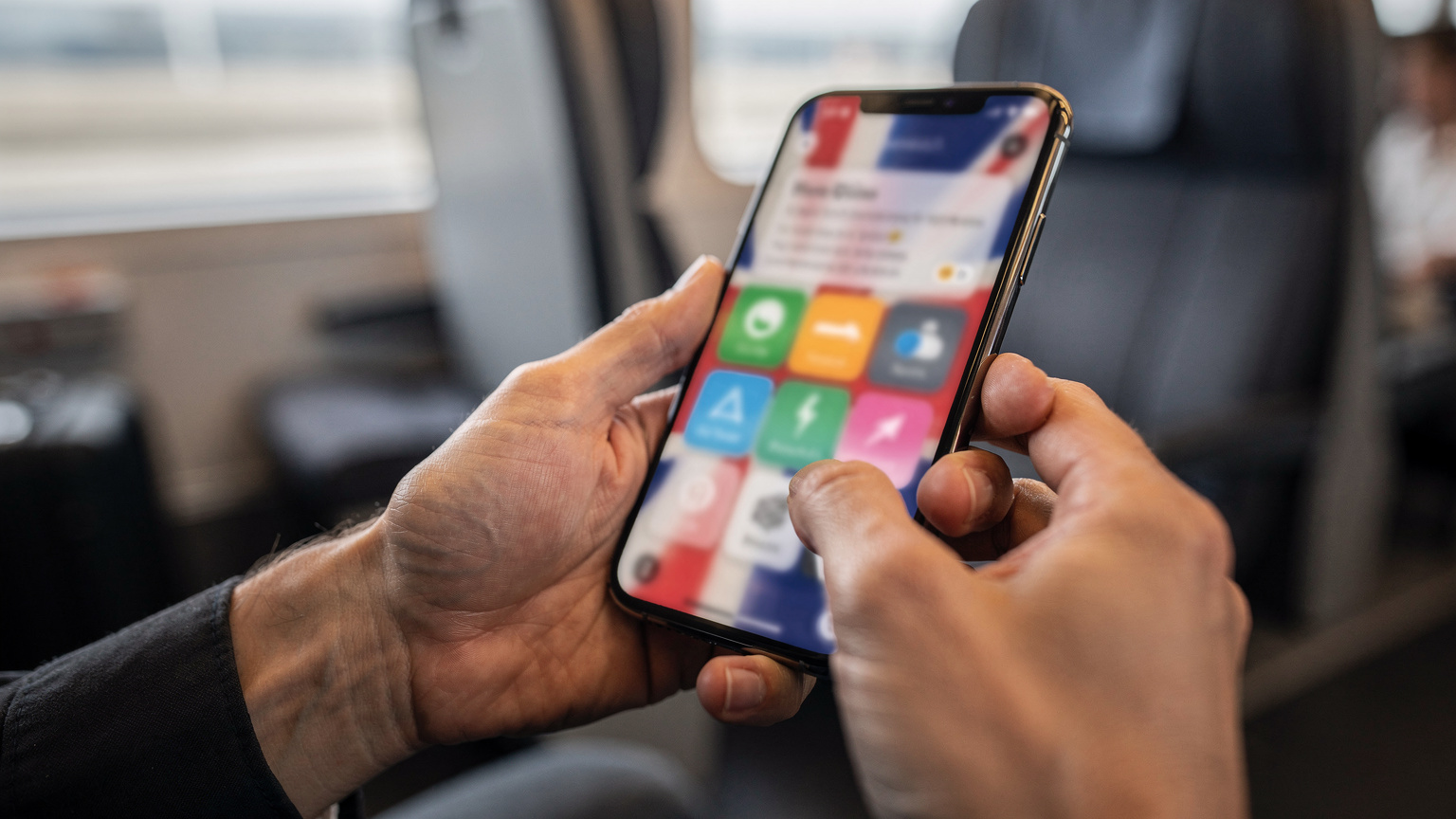 Detailní záběr rukou držících mobilní telefon, na jehož displeji je vidět aplikace Cellesim s nabídkou datových balíčků pro Velkou Británii.
