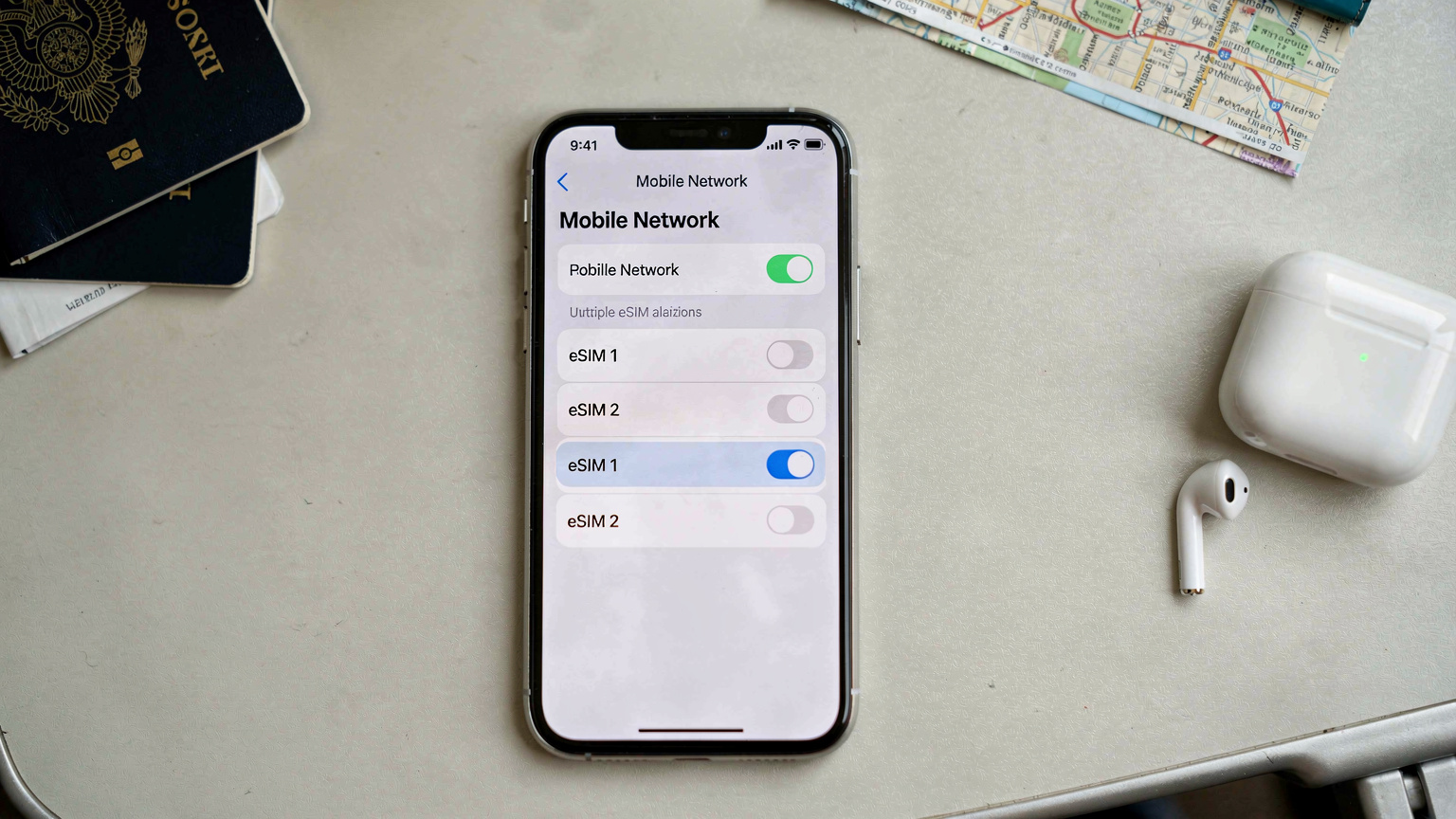 Un écran de smartphone affichant l'interface de réglages des données cellulaires, avec les options d'eSIM mises en évidence, dans un contexte de voyage avec un passeport et des écouteurs en arrière-plan.