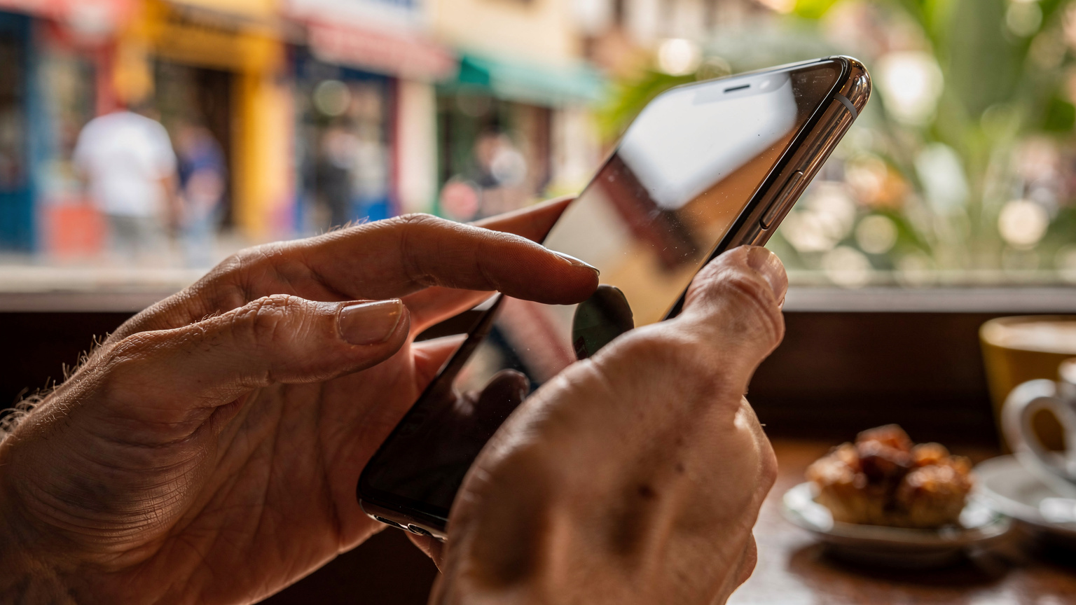 Manos de un viajero interactuando con la pantalla de un smartphone, posiblemente activando una eSIM o consultando un mapa en un contexto latinoamericano.