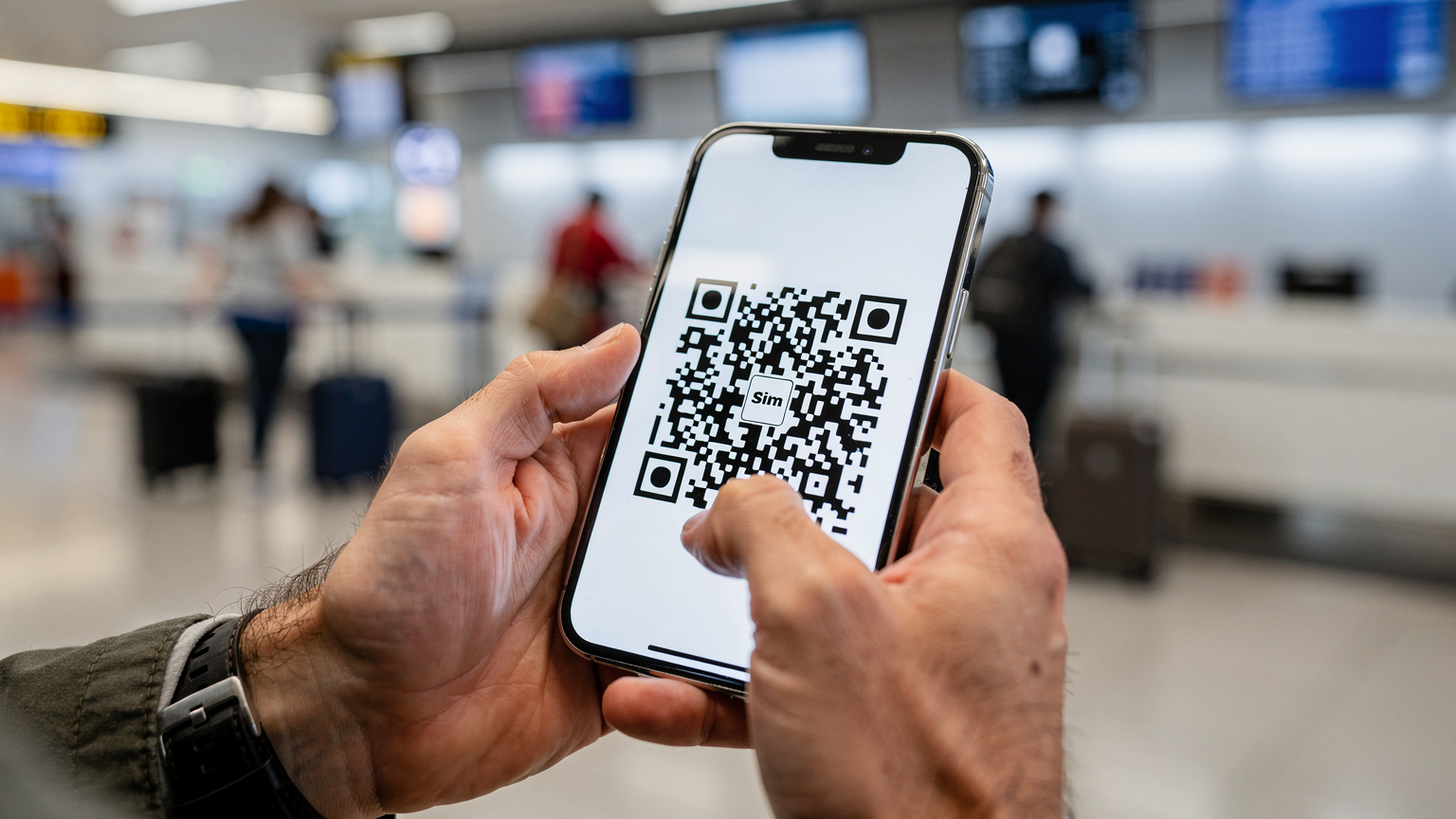 Manos de un viajero sosteniendo un smartphone, mostrando la pantalla de configuración de una eSIM con un código QR, con el fondo desenfocado de un mostrador de facturación de aeropuerto.