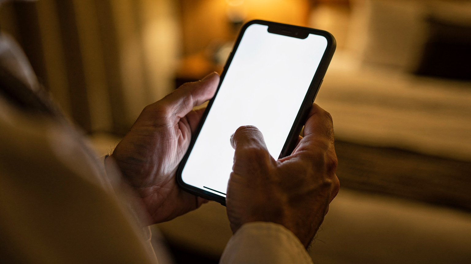 Tangan seorang jemaah haji sedang memegang telefon pintar, menatal aplikasi Cellesim untuk memilih pelan eSIM, dengan fokus pada paparan pelbagai pilihan data dan harga.