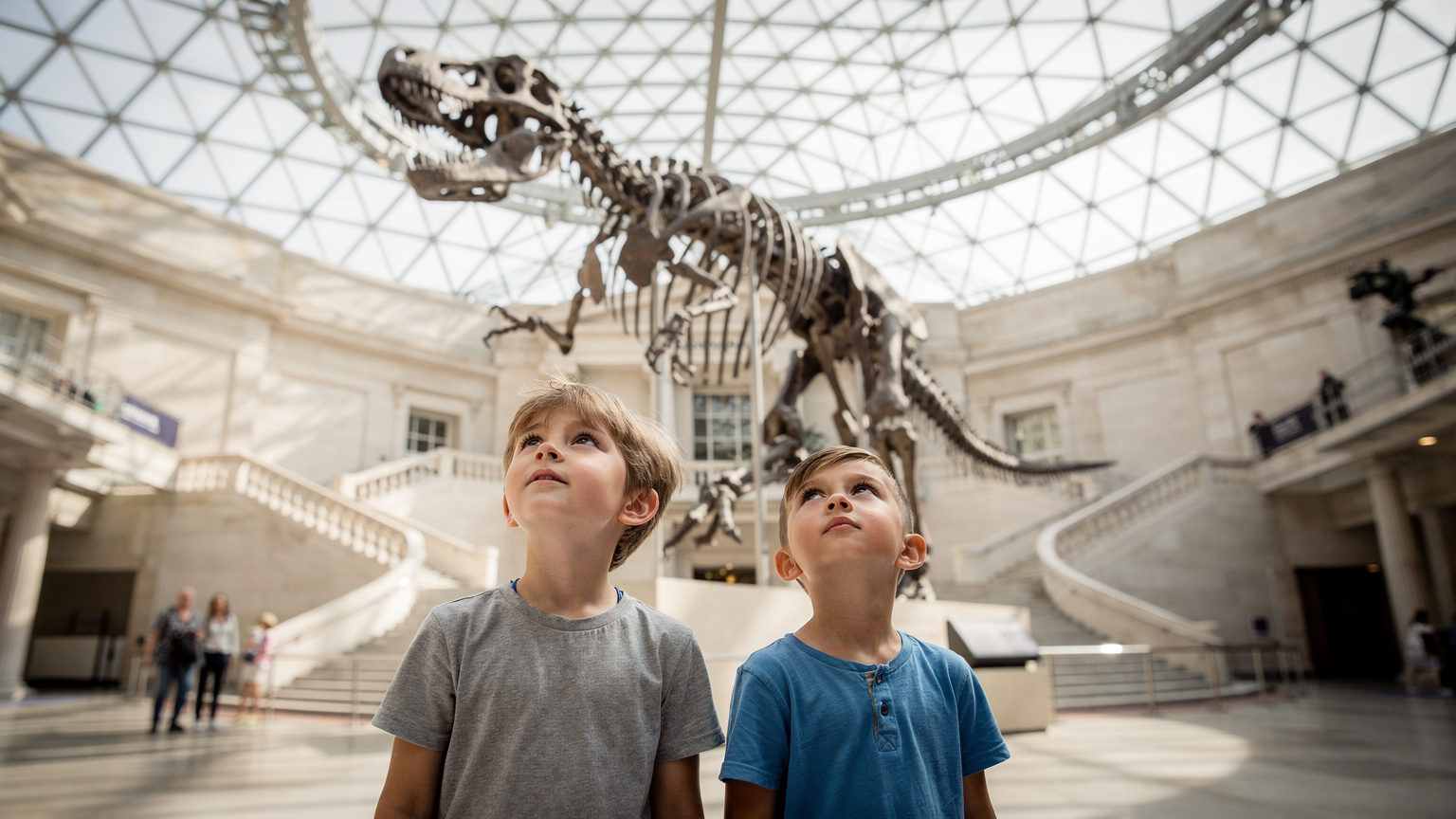 Londra'daki British Museum'un geniş, aydınlık holünde, çocuklar dinozor iskeletlerini hayranlıkla inceliyor. Müzeler, Birleşik Krallık'ta genellikle ücretsizdir ve aileler için harika bir seçenektir.