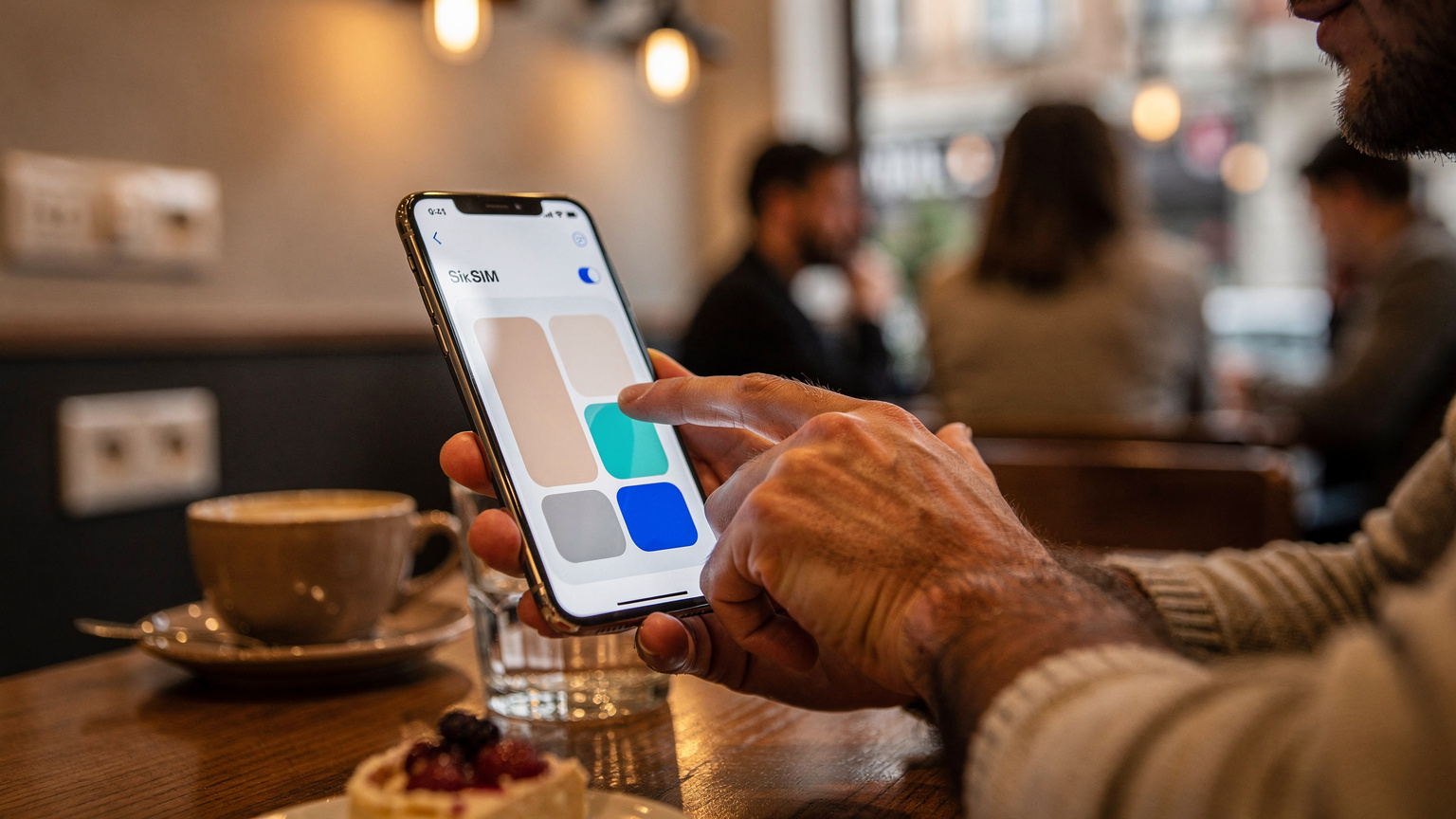 Ръце на мъж държат смартфон, показващ екрана за настройки на eSIM, докато активира нов план за данни в кокетно кафене в София.