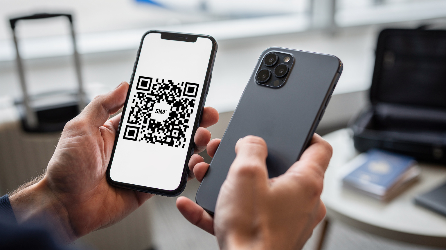 Gros plan sur des mains tenant un smartphone, avec l'écran affichant un QR code, en cours de scan par un autre smartphone tenu par les mêmes mains, symbolisant l'activation d'une eSIM, avec un fond flou de paysage de voyage.