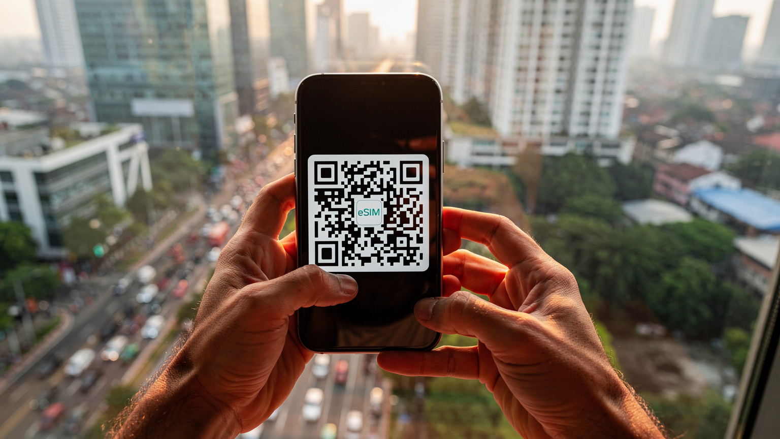 Tangan seorang pria sedang memegang iPhone dengan layar menampilkan kode QR untuk aktivasi eSIM, dengan latar belakang pemandangan kota yang sibuk di Jakarta.