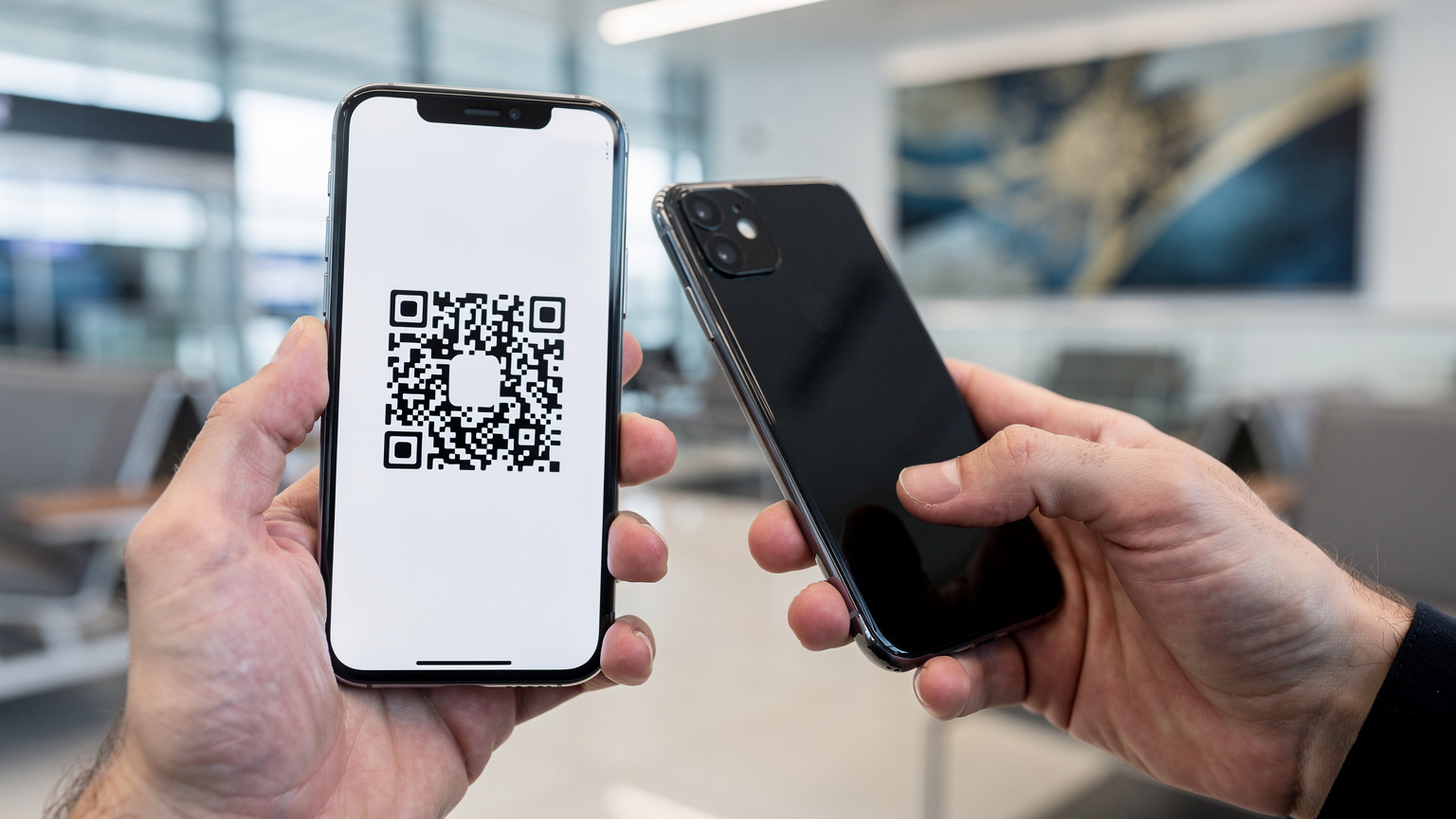 Nahaufnahme von Händen, die ein Smartphone halten, während der QR-Code für eine eSIM-Aktivierung in einem hellen, modernen Flughafen-Lounge-Bereich gescannt wird.