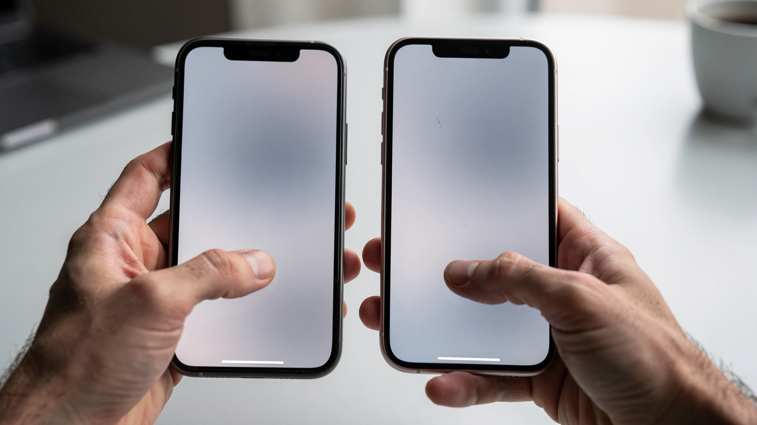 Un gros plan des mains tenant deux iPhones, un ancien et un nouveau, affichant l'écran de confirmation du transfert d'eSIM pendant le processus de migration rapide d'Apple.