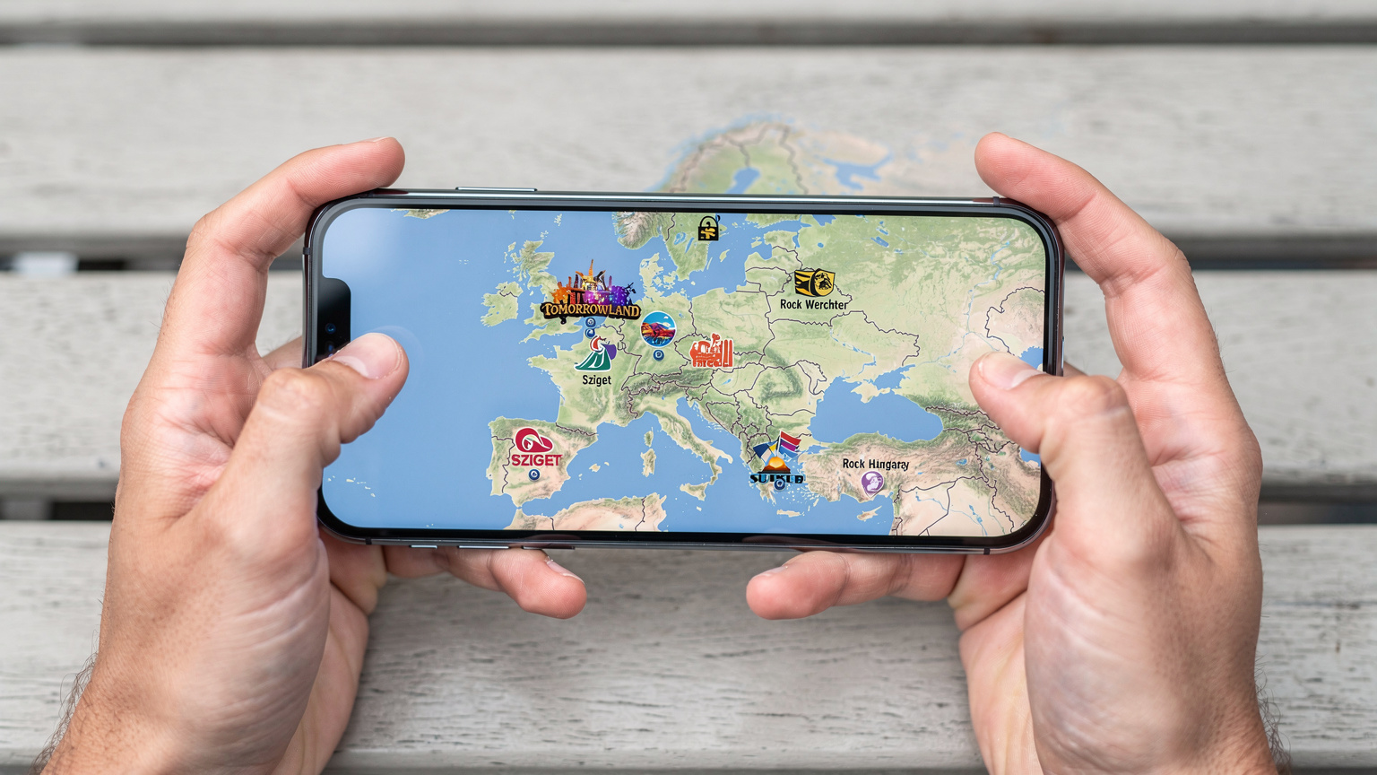 Bir festival haritası üzerinde işaretlenmiş Tomorrowland, Sziget ve Rock Werchter gibi Avrupa festivallerini gösteren bir telefon ekranına yakından bakış.