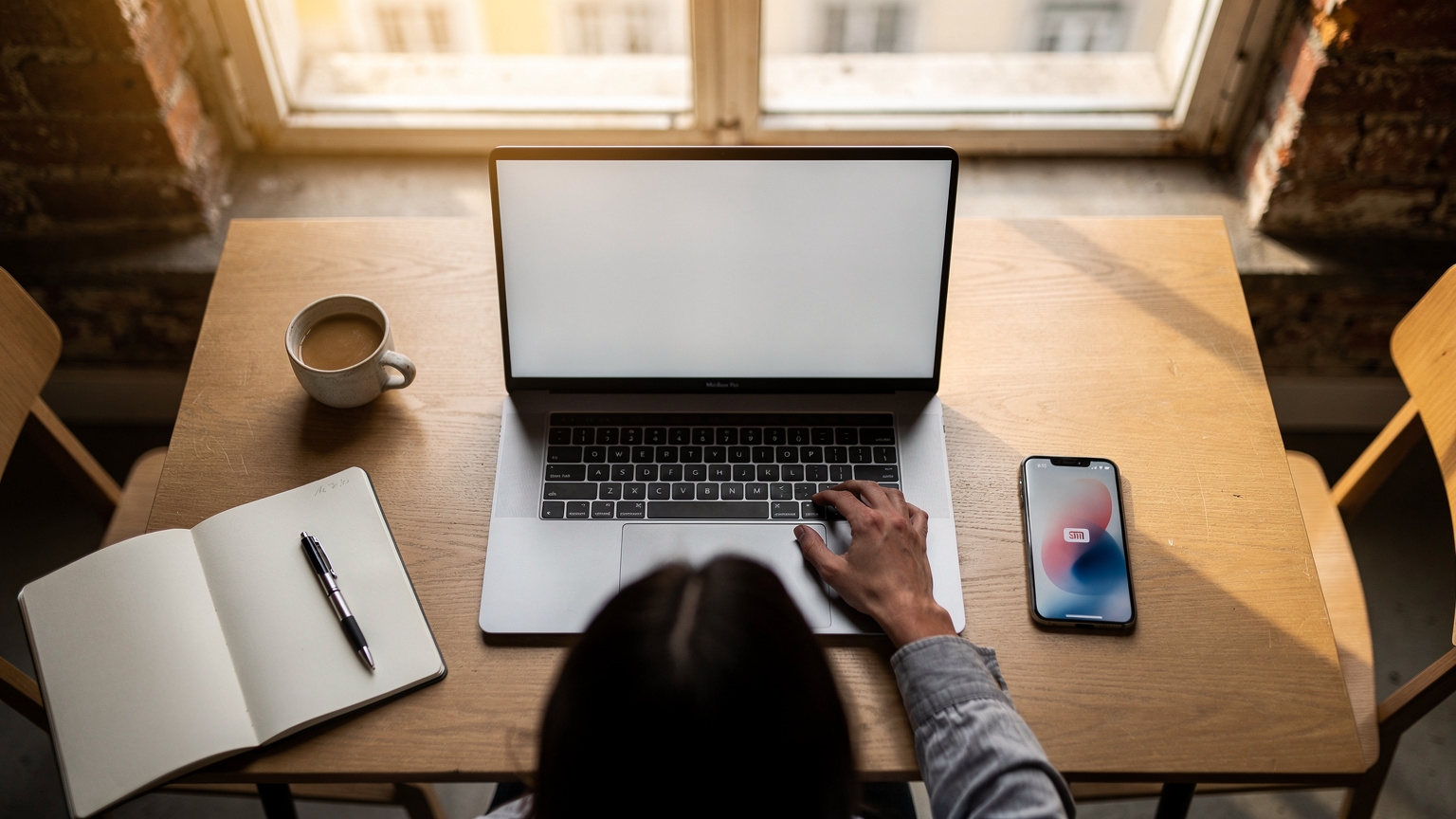 A digital nomad works on a laptop at a sunlit co-working space in Lisbon, Portugal, with a smartphone displaying an eSIM app visible on the table alongside a coffee.