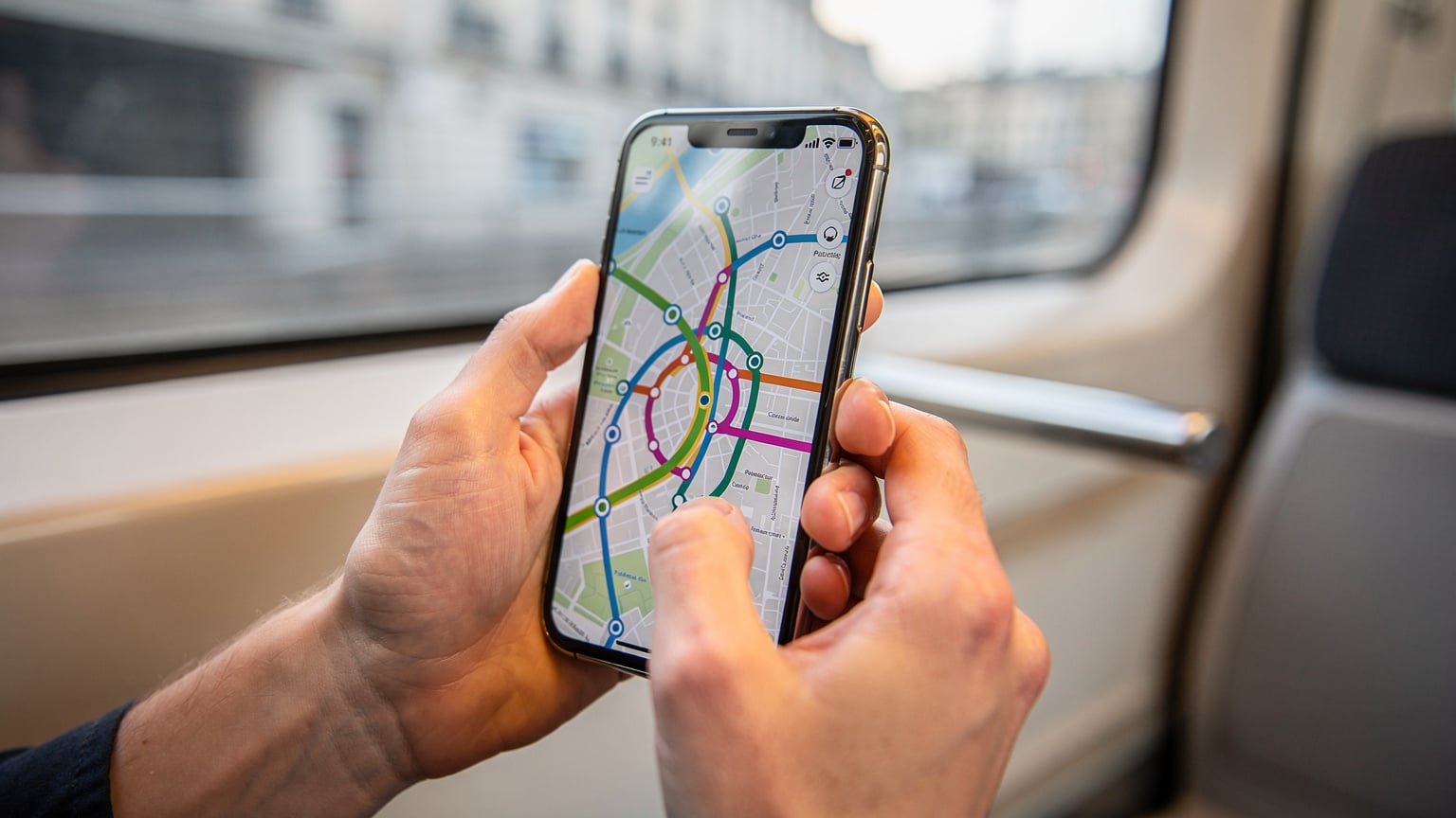 パリのメトロ車内で、スマートフォンで地図アプリを確認する旅行者の手元。画面には目的地までのルートが表示されている。