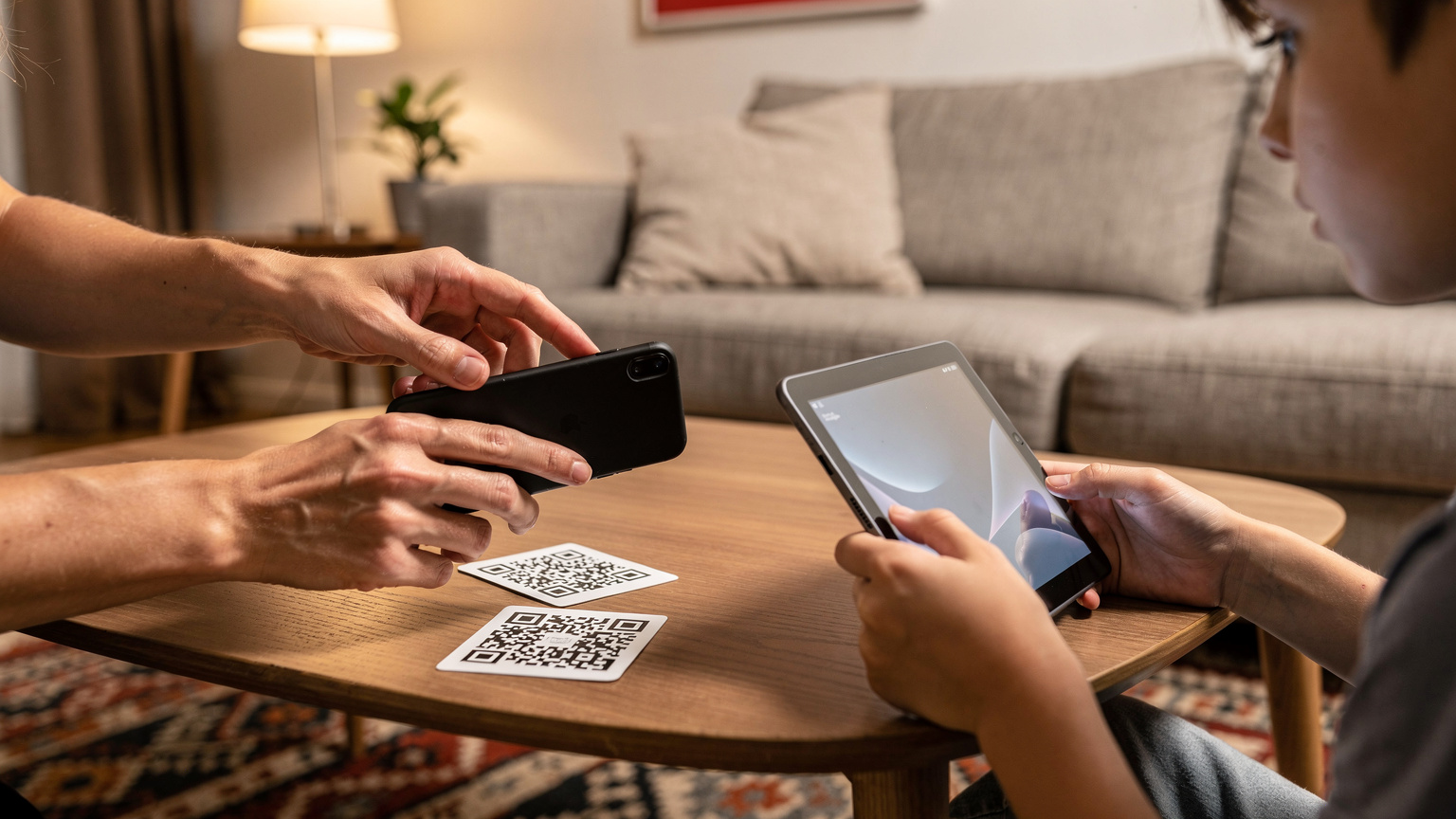 Bir anne ve çocuğunun elinde akıllı telefon ve tablet olan bir an. Anne, telefonundaki eSIM kurulumu için QR kodunu tarıyor.