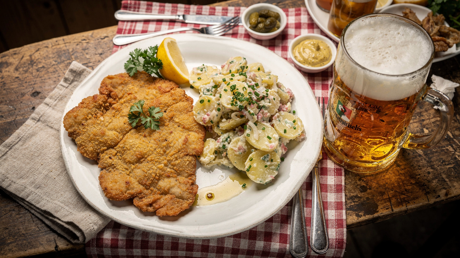 Bavyera'da geleneksel bir restoranda, schnitzel, patates salatası ve biradan oluşan zengin bir Alman sofrası.