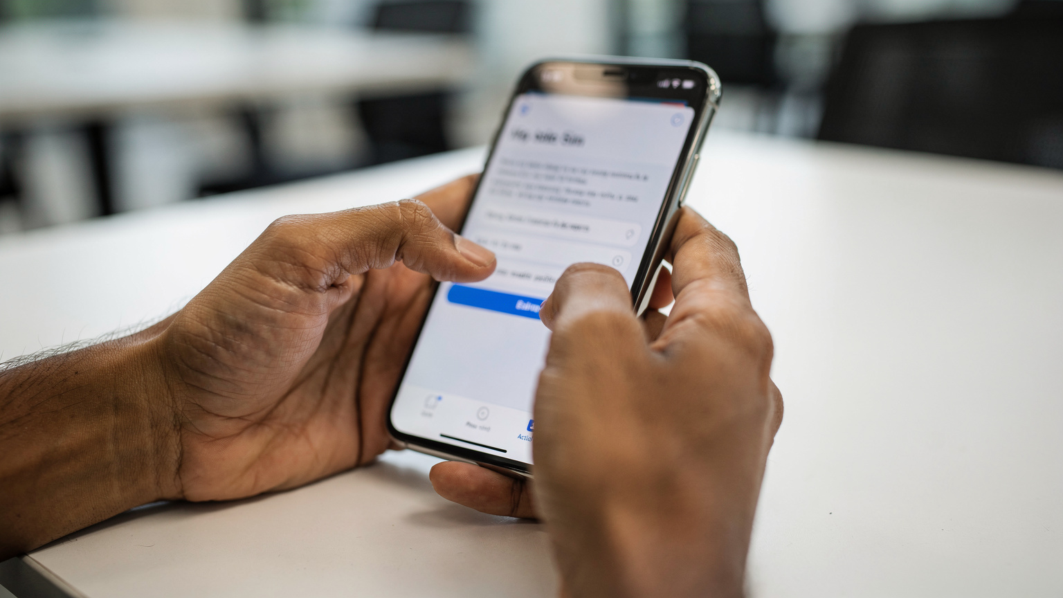 एक व्यक्ति अपने iPhone पर eSIM सेटिंग्स में मैन्युअल एक्टिवेशन विवरण दर्ज कर रहा है, उसकी उंगलियां स्क्रीन पर फोकस में हैं.