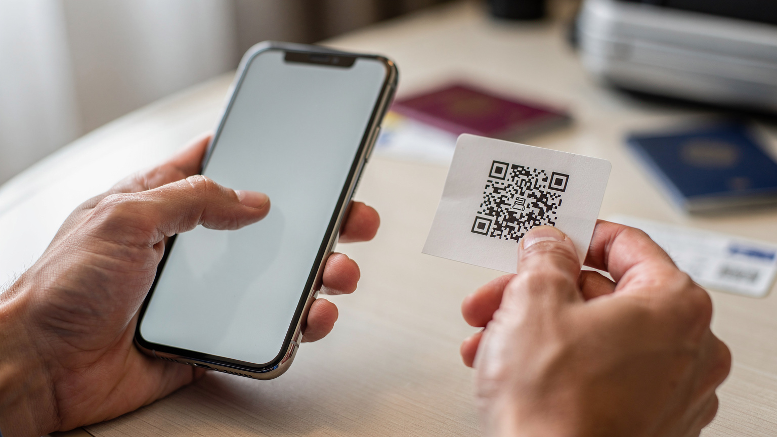 Un primer plano de manos humanas sosteniendo un smartphone, con el pulgar a punto de escanear un código QR para activar una eSIM, con un fondo ligeramente desenfocado que sugiere un entorno de viaje.