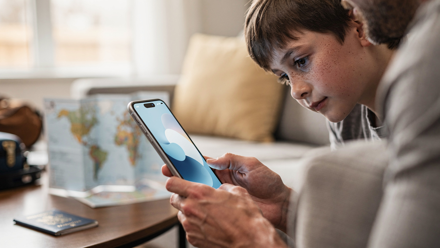 Un parent utilise son téléphone pour activer une eSIM, avec un enfant curieux observant par-dessus son épaule dans un cadre de préparation de voyage.